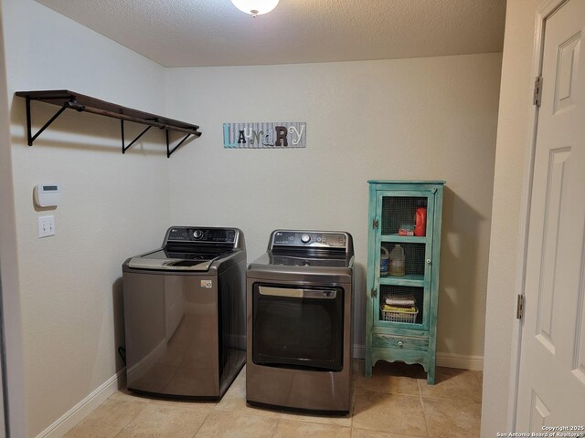 laundry area with separate washer and dryer, baseboards, laundry area, and light tile patterned floors