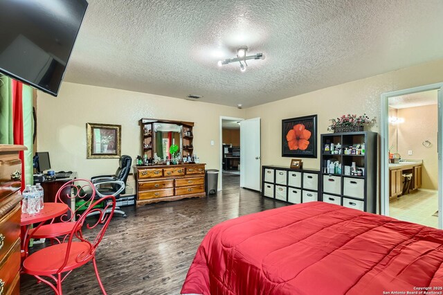 5402 Palamon Farm, San Antonio, TX 78228 - bedroom with visible vents, ensuite bathroom, wood finished floors, and a textured ceiling