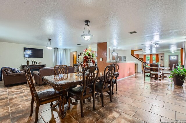 5402 Palamon Farm, San Antonio, TX 78228 - tiled dining area with plenty of natural light, baseboards, visible vents, and a textured ceiling