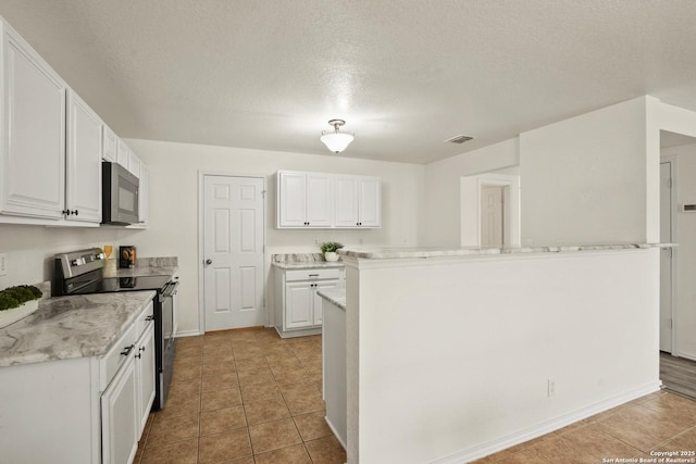 kitchen featuring light countertops, visible vents, light tile patterned floors, appliances with stainless steel finishes, and white cabinetry