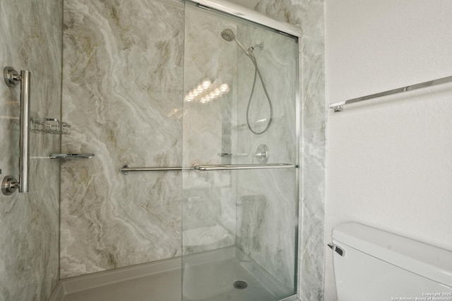 full bath featuring a marble finish shower and toilet
