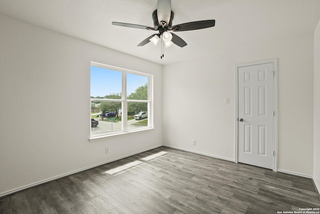 empty room with baseboards, wood finished floors, and ceiling fan