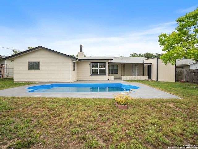 back of house with fence, a patio, a yard, and a fenced in pool