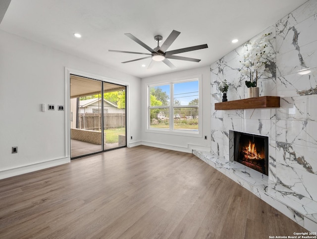 unfurnished living room featuring a ceiling fan, wood finished floors, a fireplace, and recessed lighting