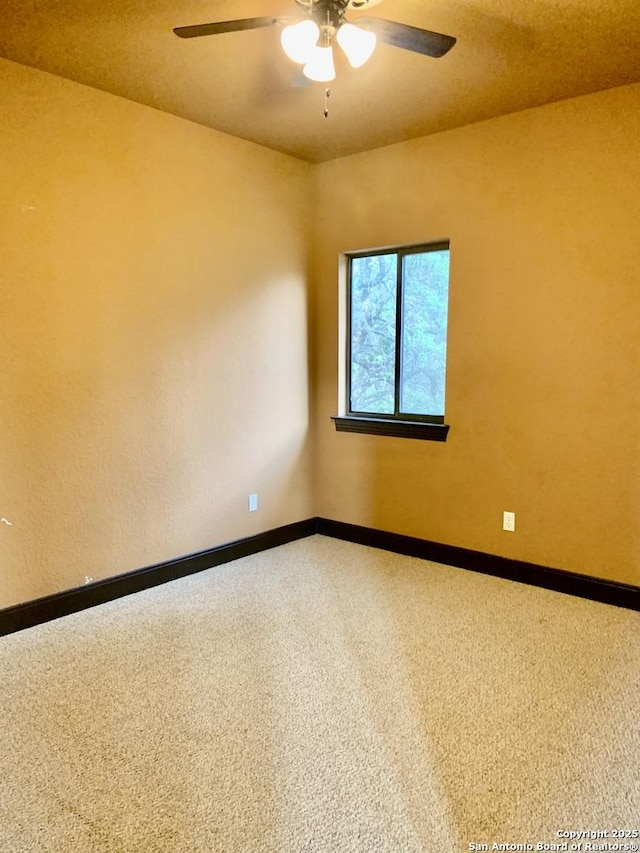 spare room featuring baseboards and ceiling fan