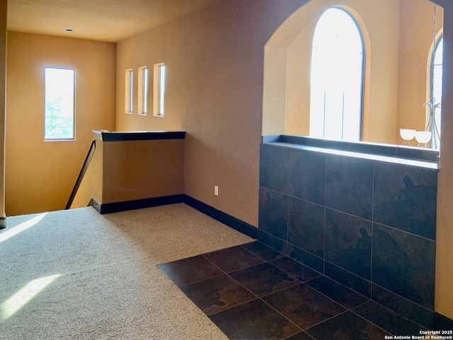 interior space with dark carpet and arched walkways