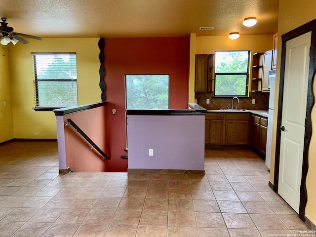 kitchen with decorative backsplash, visible vents, a textured ceiling, and a healthy amount of sunlight