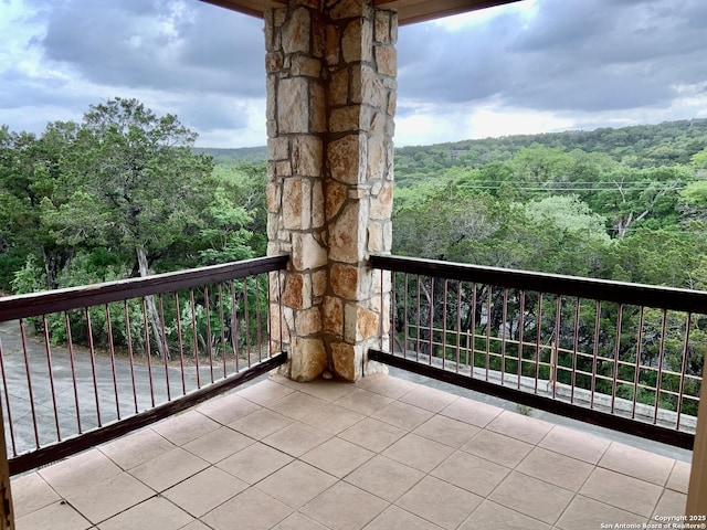 balcony featuring a wooded view