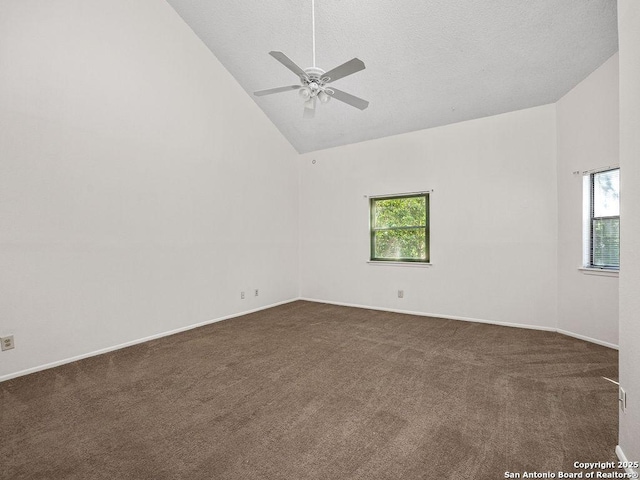 unfurnished room featuring dark colored carpet, baseboards, high vaulted ceiling, and a ceiling fan