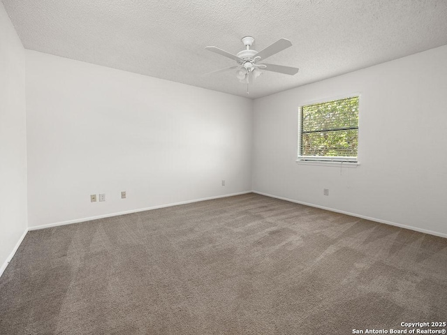 unfurnished room featuring baseboards, a ceiling fan, a textured ceiling, and carpet