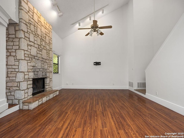 unfurnished living room with high vaulted ceiling, wood finished floors, ceiling fan, rail lighting, and visible vents