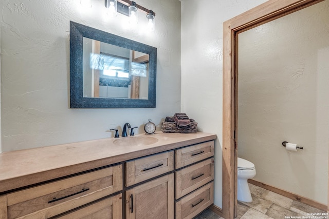 841 Postert, Floresville, TX 78114 - bathroom featuring stone finish flooring, toilet, vanity, and baseboards