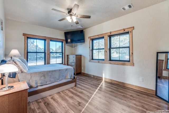 841 Postert, Floresville, TX 78114 - bedroom with baseboards, wood finished floors, visible vents, and a ceiling fan