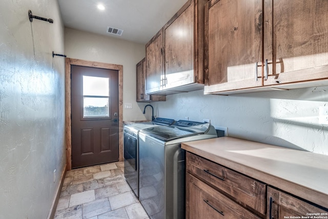 841 Postert, Floresville, TX 78114 - clothes washing area featuring washer and clothes dryer, stone tile floors, cabinet space, baseboards, and visible vents