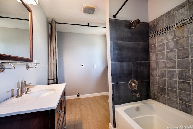 bathroom with vanity, baseboards, wood finished floors, and bathtub / shower combination
