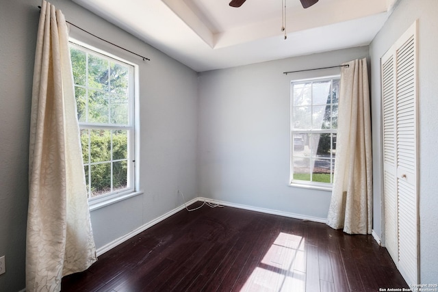 empty room with a ceiling fan, hardwood / wood-style floors, and a wealth of natural light