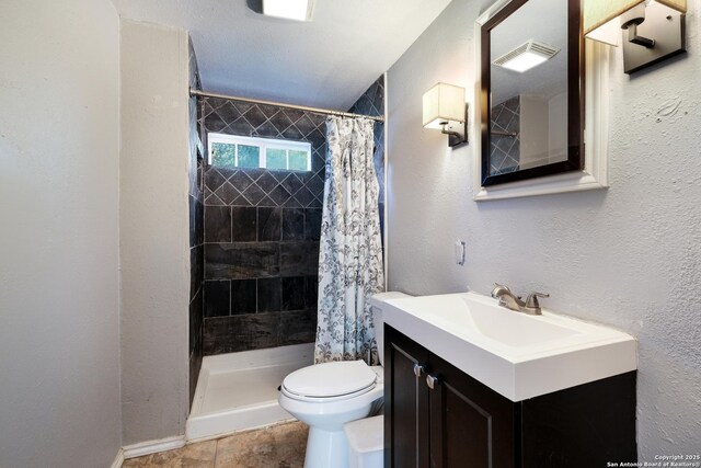 full bath with toilet, tiled shower, and vanity