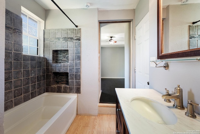 full bathroom with shower / bathtub combination, a ceiling fan, vanity, and wood finished floors