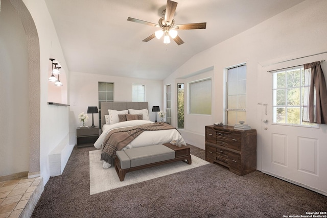 carpeted bedroom featuring arched walkways, a ceiling fan, and vaulted ceiling