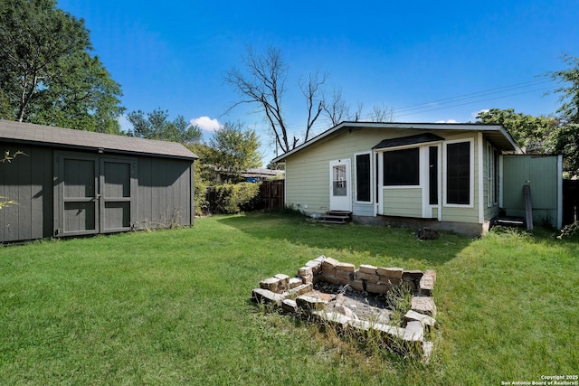 rear view of property featuring entry steps, an outbuilding, a yard, and a shed