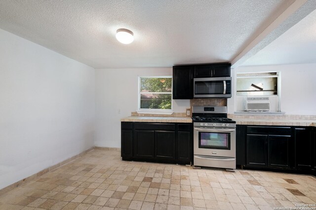 kitchen with dark cabinets, light countertops, and stainless steel appliances