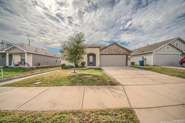 mediterranean / spanish-style home featuring an attached garage, driveway, brick siding, and a front yard
