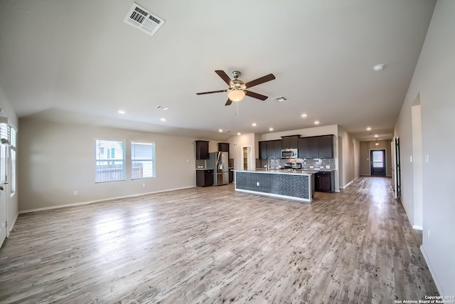 interior space featuring light wood finished floors, a ceiling fan, visible vents, and a sink