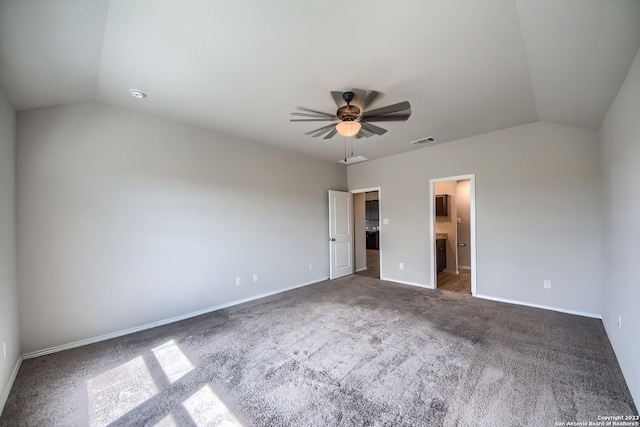 unfurnished bedroom with dark colored carpet, vaulted ceiling, visible vents, baseboards, and ceiling fan