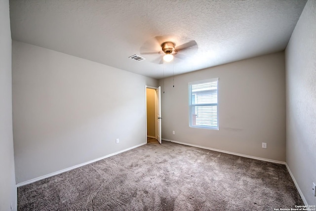 carpeted spare room with baseboards, visible vents, and ceiling fan