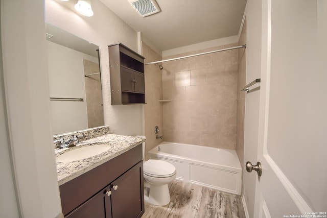 bathroom featuring shower / washtub combination, wood finished floors, visible vents, toilet, and vanity
