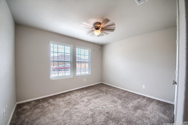 carpeted spare room featuring visible vents, a ceiling fan, and baseboards