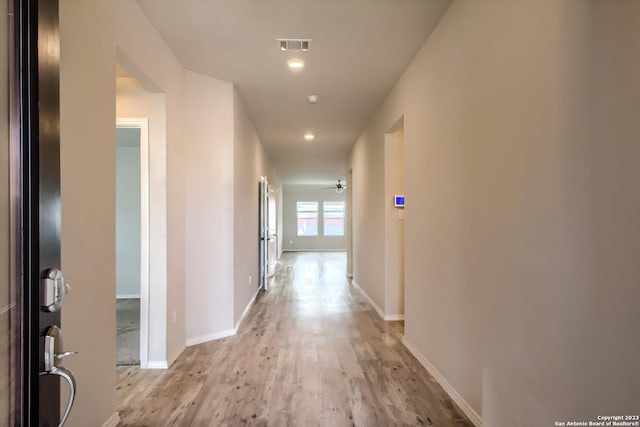hallway featuring recessed lighting, light wood-style flooring, visible vents, and baseboards
