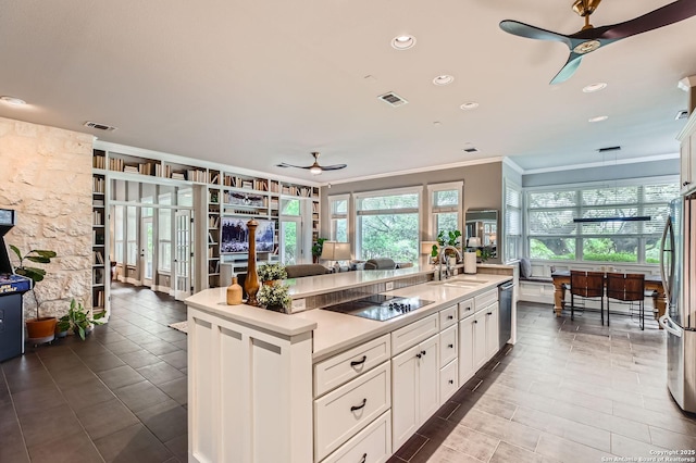 kitchen featuring visible vents, ceiling fan, stainless steel appliances, and ornamental molding