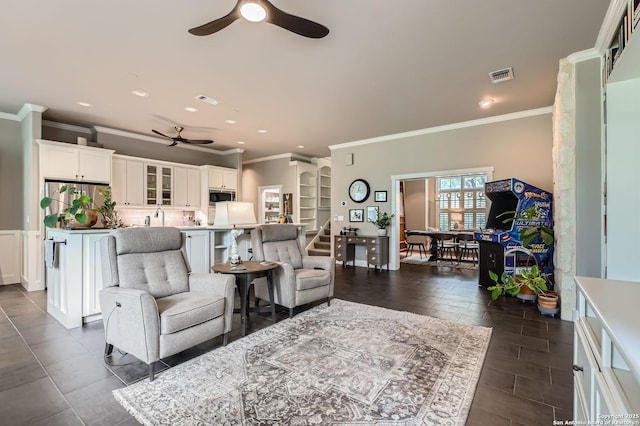 living area with a ceiling fan, visible vents, recessed lighting, and ornamental molding