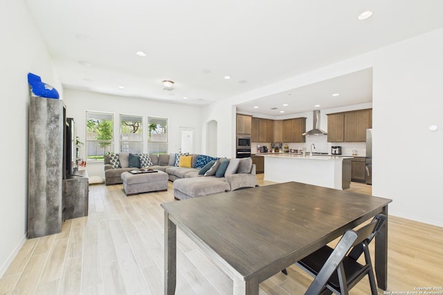 dining area featuring light wood-type flooring, baseboards, and recessed lighting
