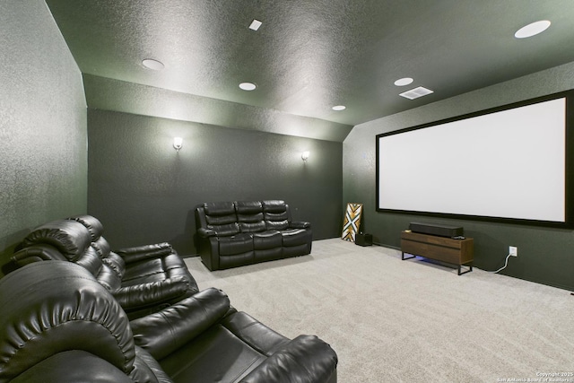 cinema with a textured wall, visible vents, and carpet
