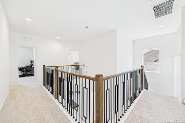 hallway with recessed lighting, visible vents, carpet flooring, and an upstairs landing
