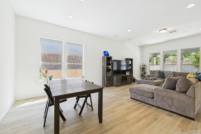 living room featuring light wood finished floors, baseboards, visible vents, and recessed lighting