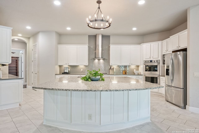 30336 Setterfeld Cir, Fair Oaks Ranch, TX 78015 - kitchen with tasteful backsplash, wall chimney range hood, appliances with stainless steel finishes, and white cabinetry