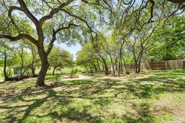 30336 Setterfeld Cir, Fair Oaks Ranch, TX 78015 - view of yard featuring fence, an outdoor fire pit, and a trampoline