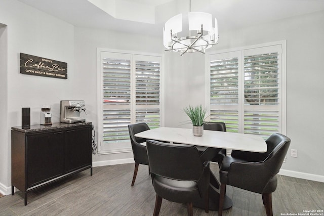 dining area featuring baseboards, wood finished floors, and a chandelier