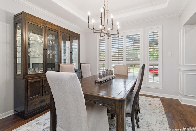 dining area featuring baseboards, dark wood-style flooring, a notable chandelier, and a raised ceiling