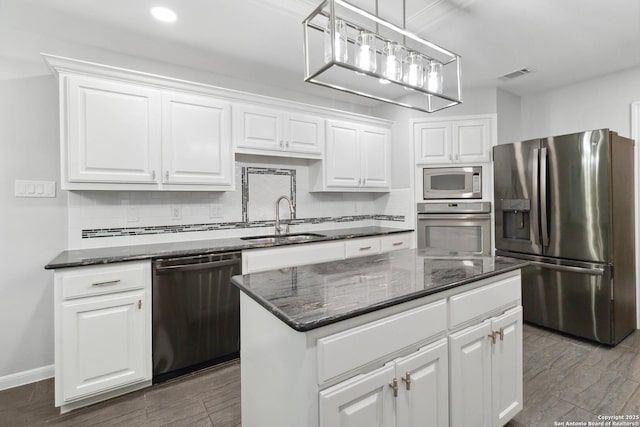 kitchen with white cabinets, backsplash, visible vents, a sink, and appliances with stainless steel finishes