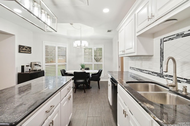 kitchen featuring recessed lighting, white cabinets, backsplash, a sink, and a chandelier
