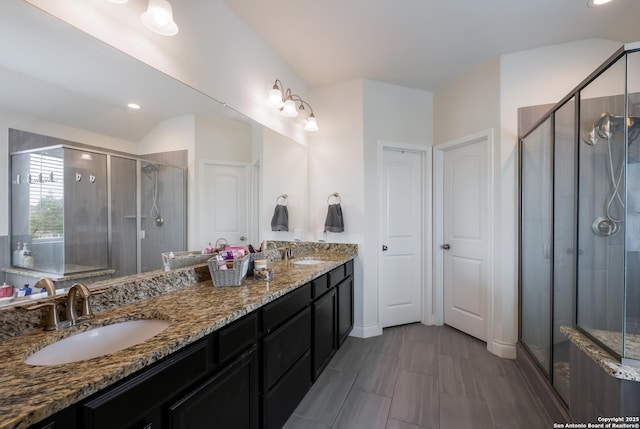 bathroom with double vanity, a stall shower, and a sink