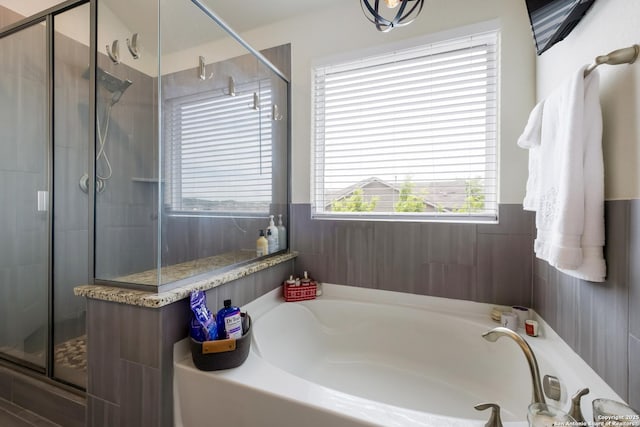 bathroom featuring a bath and a shower stall