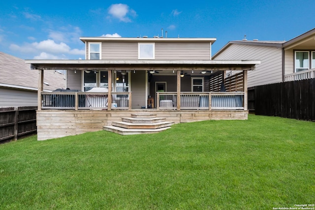 rear view of property with a lawn, a fenced backyard, and a ceiling fan