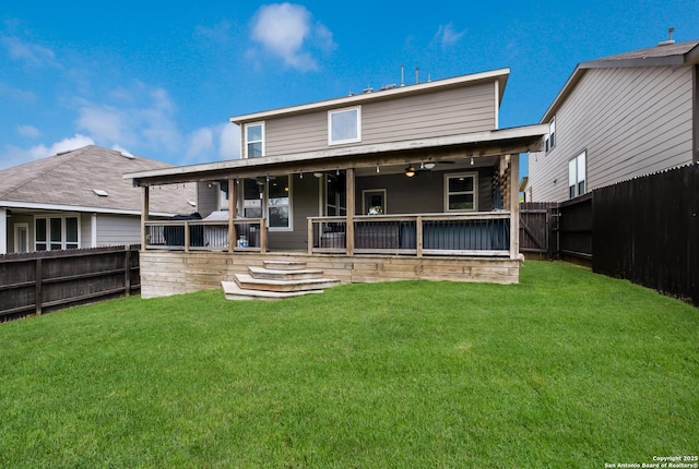 back of property featuring a yard, a ceiling fan, and a fenced backyard