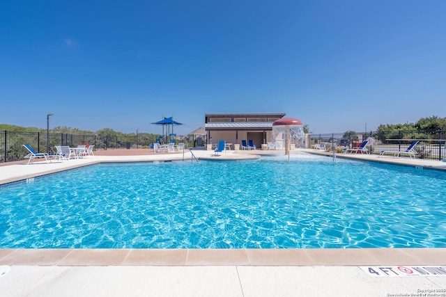 community pool with fence and a patio
