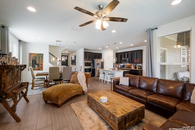 living area featuring recessed lighting, visible vents, and a ceiling fan